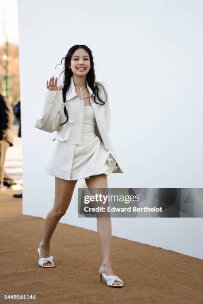 Jennie Kim from Blackpink wears a white oversize jacket, a necklace, a white ruffled and gathered mini dress, a white fluffy bag from Jacquemus,...