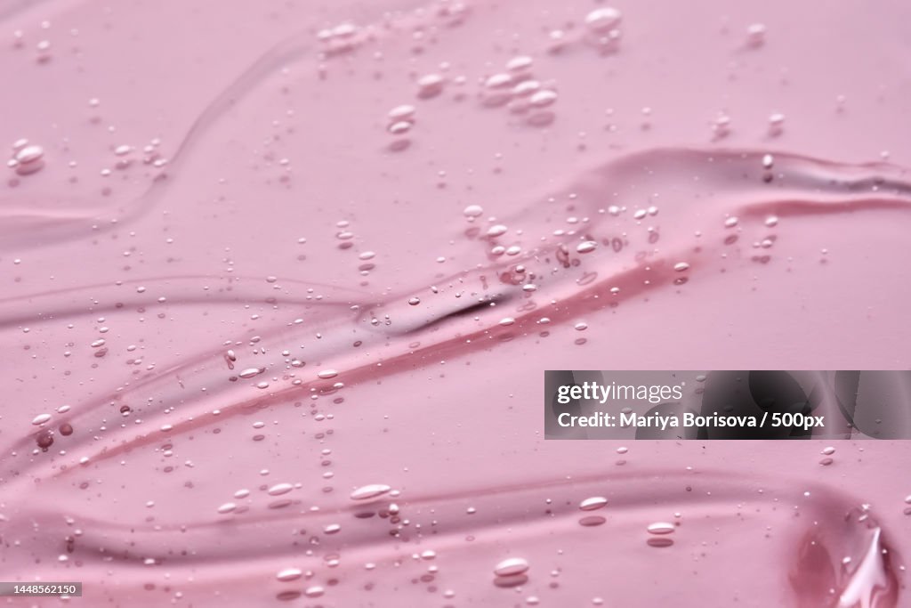 The texture of the cosmetic gel on a pink background
