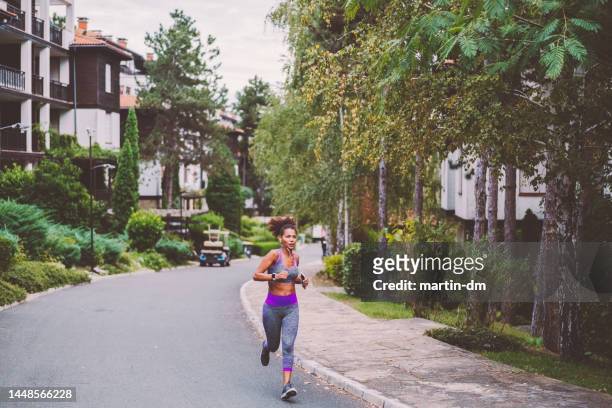 woman jogging in outside - atletendorp stockfoto's en -beelden