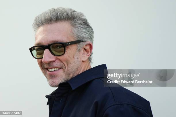 Vincent Cassel wears sunglasses, a Jacquemus blue denim jacket, outside the "Le Raphia" Jacquemus show on December 12, 2022 in Le Bourget, France.