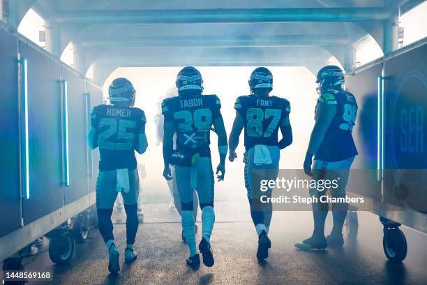 Travis Homer, Teez Tabor, Noah Fant and Al Woods of the Seattle Seahawks take the field before the game against the Carolina Panthers at Lumen Field...