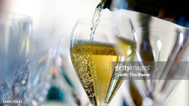 champagne being poured into a glass. - glass of prosecco stockfoto's en -beelden