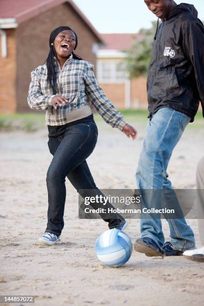 Girl and Boy kicking Soccer Ball