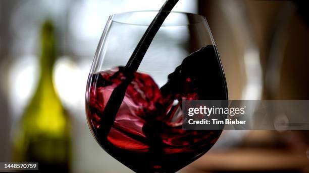wine being poured into a glass. - maroon swirl stock pictures, royalty-free photos & images