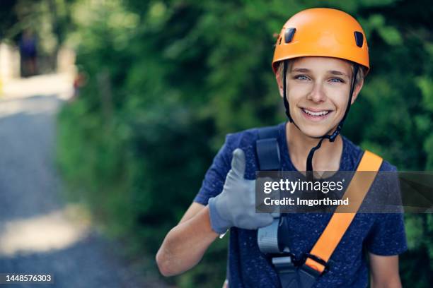 teenager hat spaß im hochseilgarten abenteuerpark - hochseilgarten stock-fotos und bilder