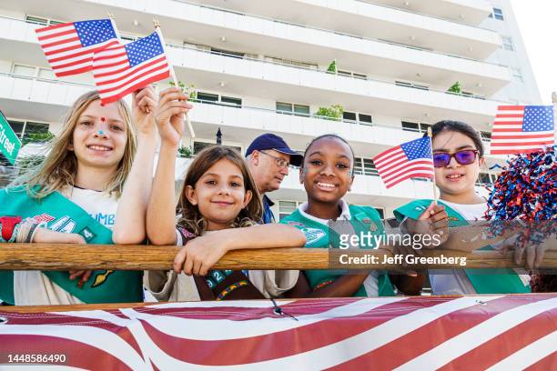 Miami Beach, Florida, Veterans Day Parade, Girl Scouts of America and Brownies holding American flags and cheering.