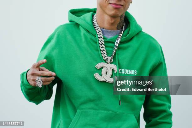 Central Cee wears a Chanel large logo necklace, a green hoodie