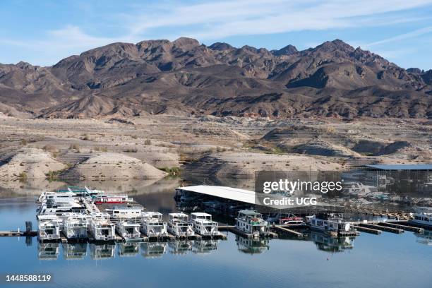 Existing boats and docks in Lake Mead with strandlines left by the falling lake levels in the background, Nevada.