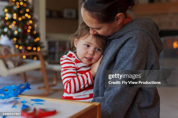 douce petite fille passant noël avec sa mère - mère célibataire photos et images de collection