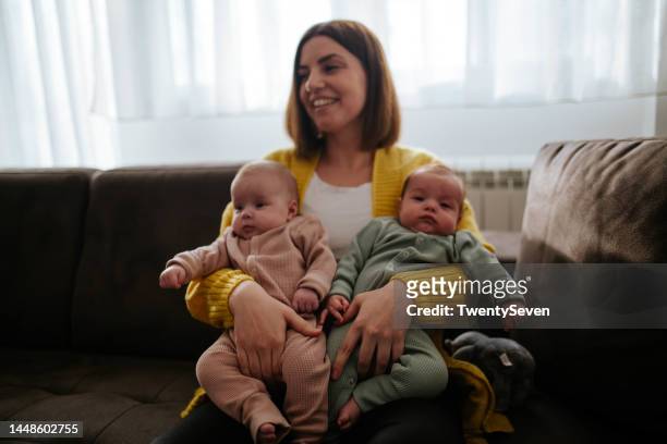 madre feliz con sus gemelos - twin fotografías e imágenes de stock