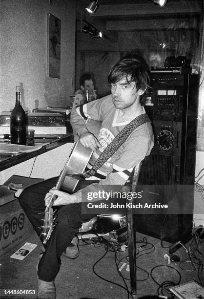 Portrait of British Rock musician Chris Spedding, an acoustic guitar in his lap, as he sits at home, New York, New York, 1982.