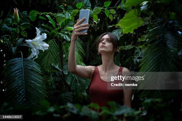 woman has lost a mobile signal in the forest - cell phone confused stock pictures, royalty-free photos & images