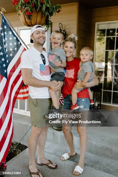 happy family celebrating independence day - blue house red door stock pictures, royalty-free photos & images