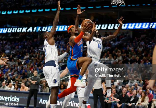 Shai Gilgeous-Alexander of the Oklahoma City Thunder drives to the basket against Dorian Finney-Smith of the Dallas Mavericks and Tim Hardaway Jr....