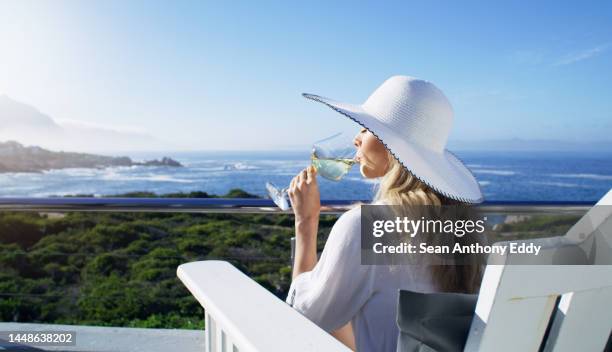 relax, wine and ocean holiday with a woman on vacation at a luxury resort or villa and a beautiful view of the sea and sky. nature, water and alcohol with a young female enjoying a drink outside - anthony summers stock pictures, royalty-free photos & images