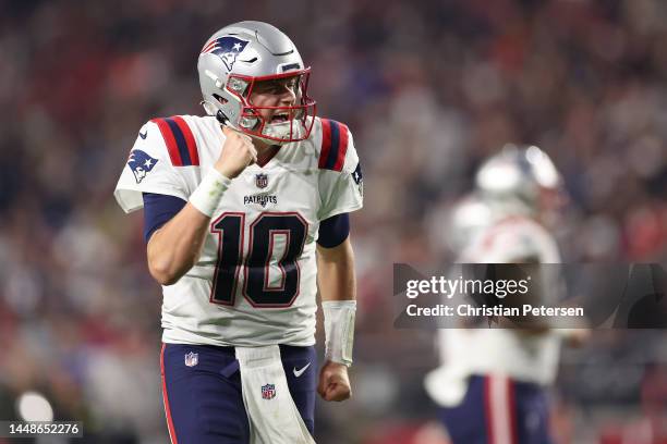 Mac Jones of the New England Patriots celebrates a touchdown scored by Pierre Strong Jr. #35 against the Arizona Cardinals during the fourth quarter...