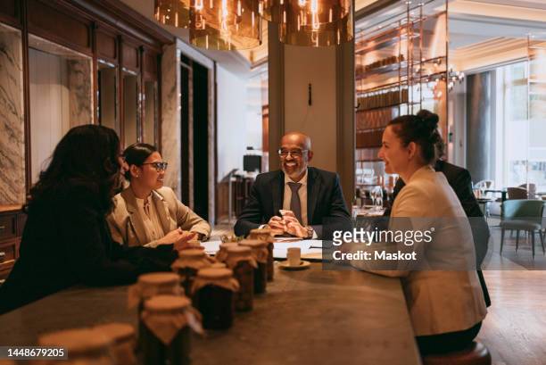 smiling multiracial colleagues at dining table during lunch meeting in restaurant - business lunch stock pictures, royalty-free photos & images