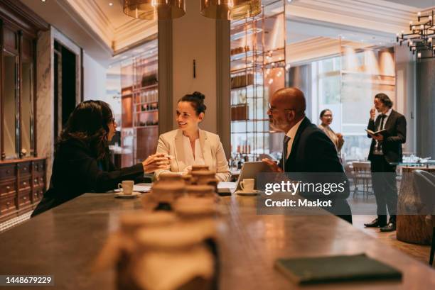 multiracial male and female colleagues discussing at lunch meeting in restaurant - business lunch stock-fotos und bilder