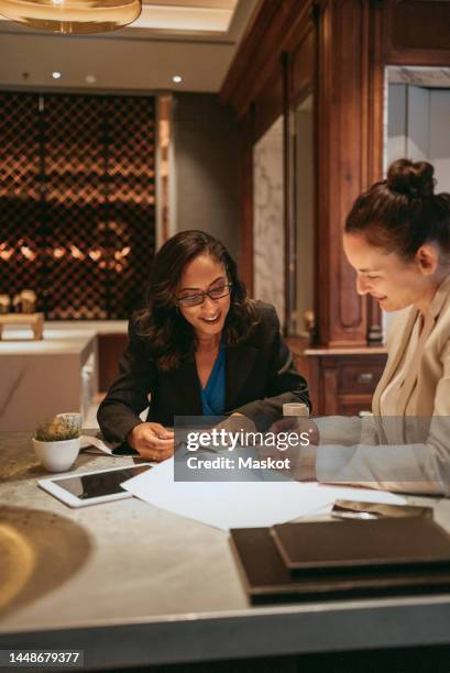 smiling businesswomen discussing over documents at table in restaurant - meal deal stock pictures, royalty-free photos & images