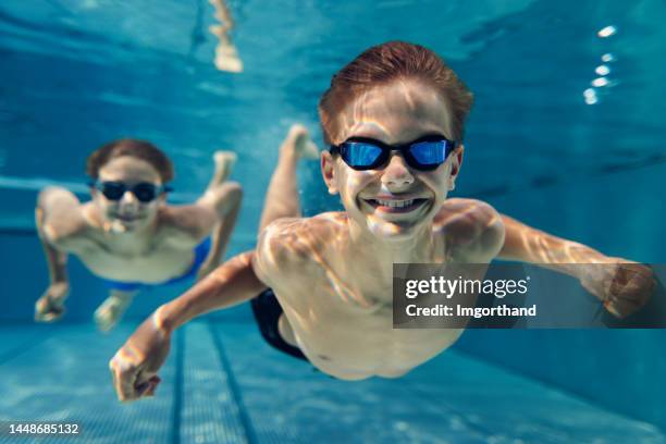 teenage kids swimming underwater in the swimming pool - boy swimming pool stock pictures, royalty-free photos & images