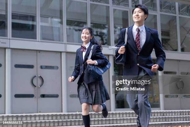 high school boy and girl running - japanese school uniform imagens e fotografias de stock