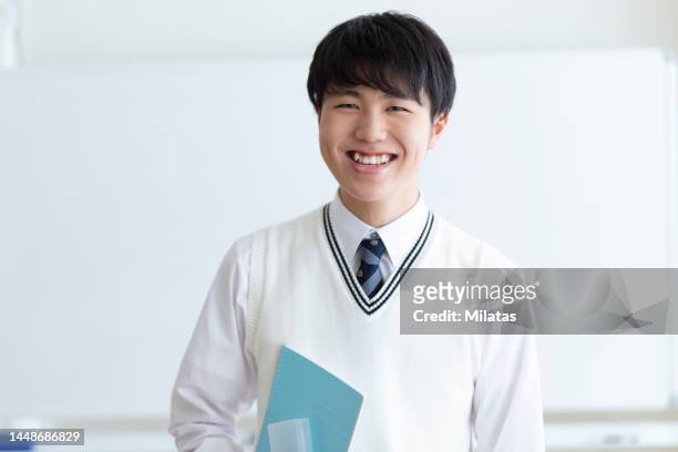 portrait of a high school student standing in a classroom - 少年 ストックフォトと画像