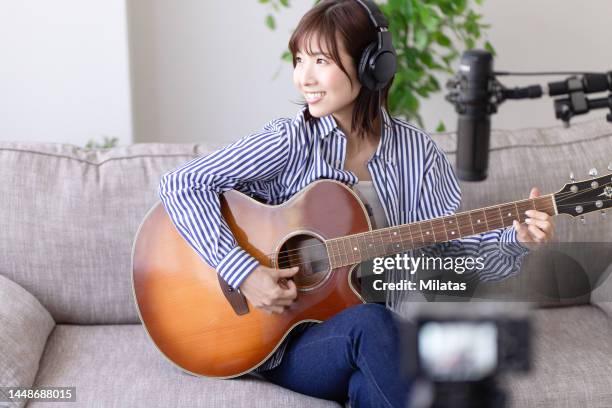 a woman is live streaming - cantautor fotografías e imágenes de stock