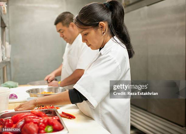 young woman prepares bell peppers - hair back stock pictures, royalty-free photos & images