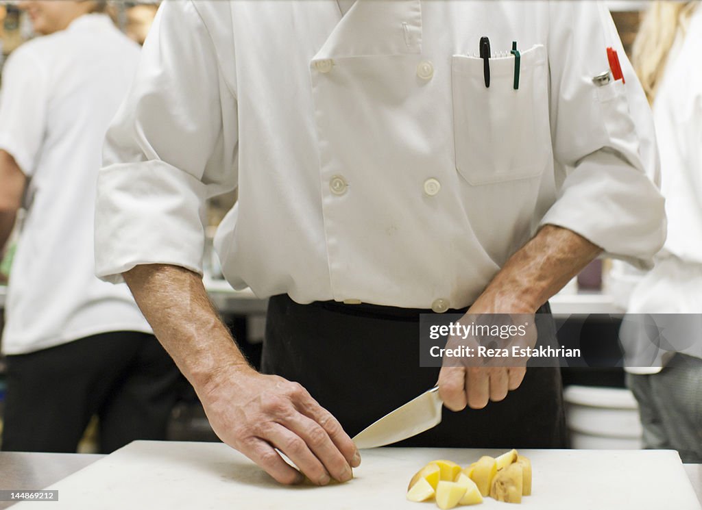 Chef chops potatoes