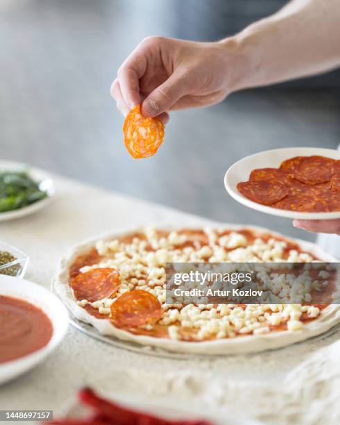 pizza with paroni and cheese. process of making pizza. chef prepares pizza in kitchen. pizza recipe. italian food. soft focus - pizza chef stock pictures, royalty-free photos & images