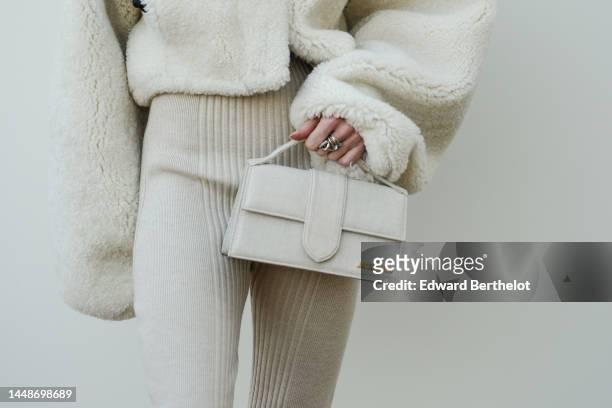 Julia Hobbs wears a white latte sheep fluffy oversized jacket, a white latte / beige matte east-west handbag from Jacquemus, beige ribbed wool...