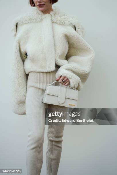 Julia Hobbs wears a white latte sheep fluffy oversized jacket, a white latte / beige matte east-west handbag from Jacquemus, beige ribbed wool...