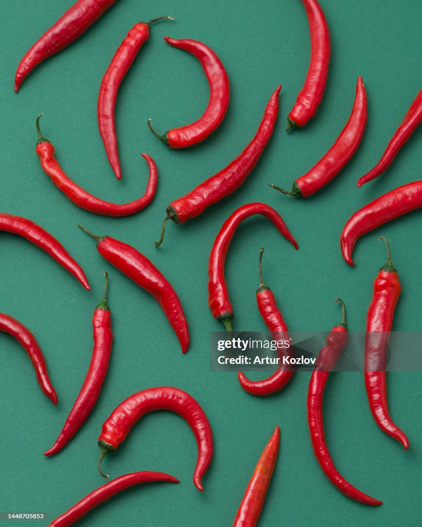 Red hot peppers on red background. Chili and cayenne peppers. Vegetarian food. Vegetables. Bright spices. Sauce ingredient. Photo for advertising. Mexican cuisine. Spicy food. View from above