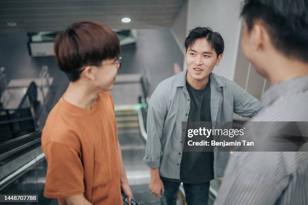 3 generation z asian chinese teenage boy talking while riding on escalator - asian generation z stock pictures, royalty-free photos & images