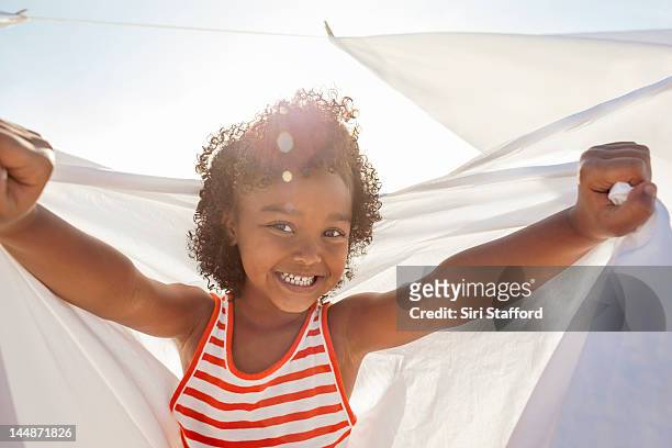 young girl smiling, holding white sheet - day 4 stockfoto's en -beelden