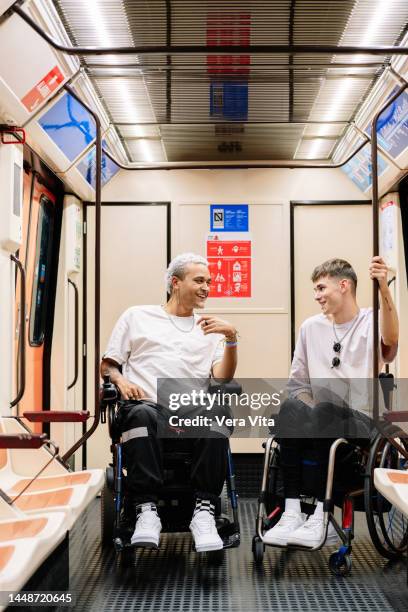 latin american students young men on wheelchair travel on subway - fauteuil handicap stock pictures, royalty-free photos & images