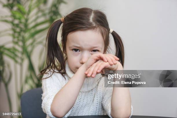 portrait lonely 5 years old girl looks unhappy and pensive, covering her face by hands and screw up one's eyes - 6 7 years stock pictures, royalty-free photos & images