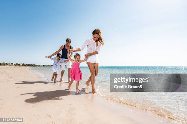 young happy family walking on the beach. - familie am strand stock pictures, royalty-free photos & images