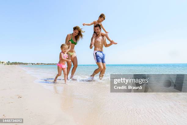 unbeschwerte familie ein spaß tag am strand. - boy and girl running along beach holding hands stock-fotos und bilder