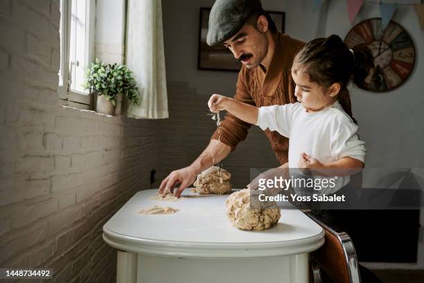 father and daughter dusting flour to make bread - celiac disease stock pictures, royalty-free photos & images