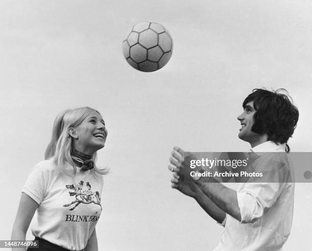 Northern Irish footballer George Best throwing a football to his Danish fiancee Eva Haraldsted. She is wearing a Blinkers United t-shirt. Blinkers...