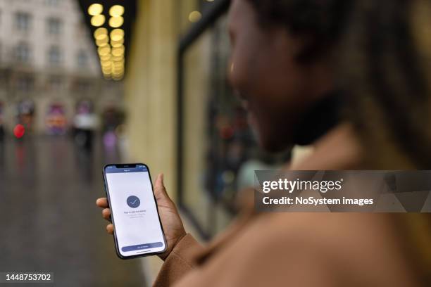 black woman signing in to a mobile app - login stock pictures, royalty-free photos & images