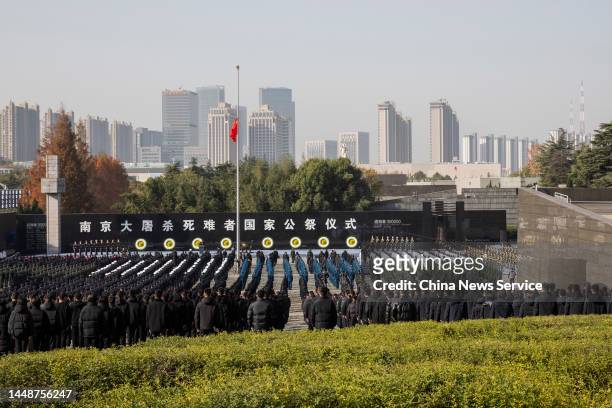 China's national flag flies at half mast as people attend the state memorial ceremony for China's National Memorial Day for Nanjing Massacre Victims...