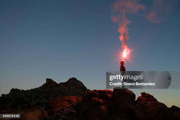 man holding flare at sunset. - distress flare stock pictures, royalty-free photos & images