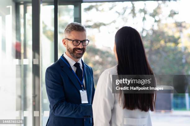businessman shaking hands with young doctor. - hospital director stock pictures, royalty-free photos & images