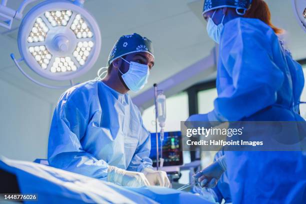 close-up of surgeon team during operation. - operating gown stock pictures, royalty-free photos & images