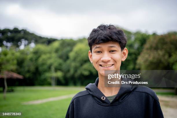 porträt eines asiatischen jungen, der im park spielt - season 15 stock-fotos und bilder