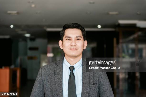 portrait of asian businessman in office lobby - indonesian ethnicity stock pictures, royalty-free photos & images