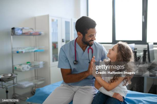 portrait of multiracial doctor with little girl. - nurse child stock-fotos und bilder