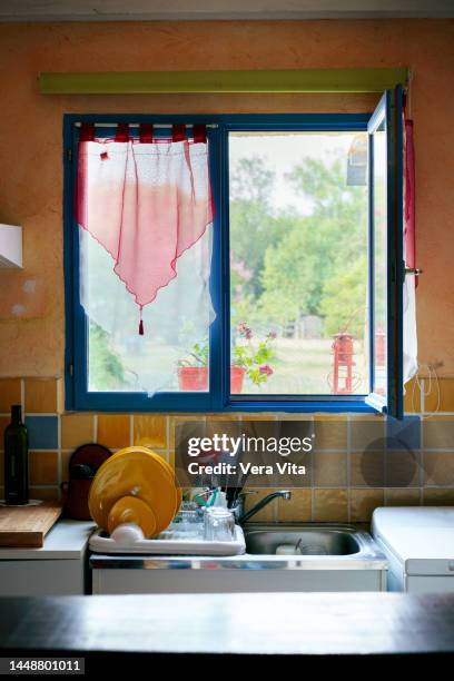 close up of kitchen sink with clean dishes and rustic decoration in countryside. - vita domestica fotografías e imágenes de stock